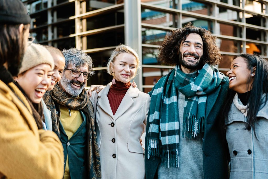 Group of diverse multi generational business expatriates standing together outdoors